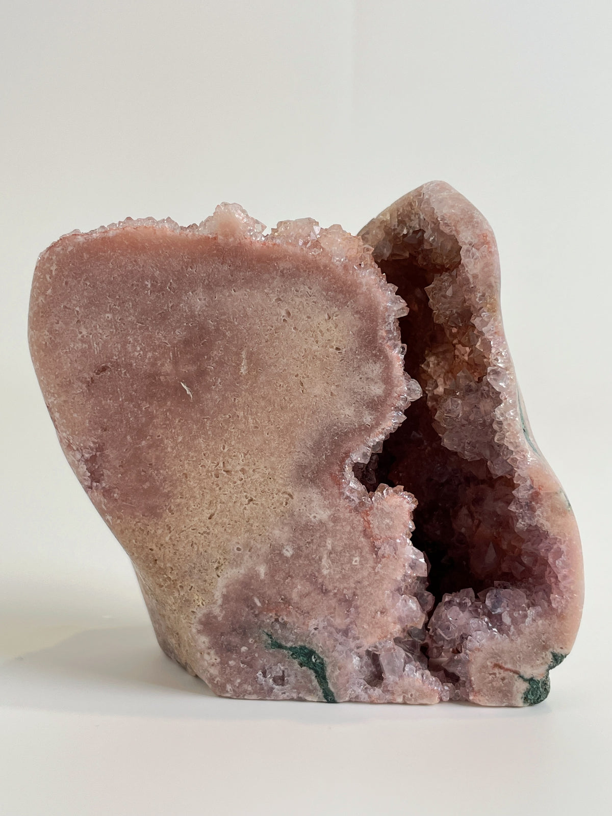 Botryoidal pink amethyst freeform specimen with a smooth exterior and sparkling interior, showcasing natural beauty.
