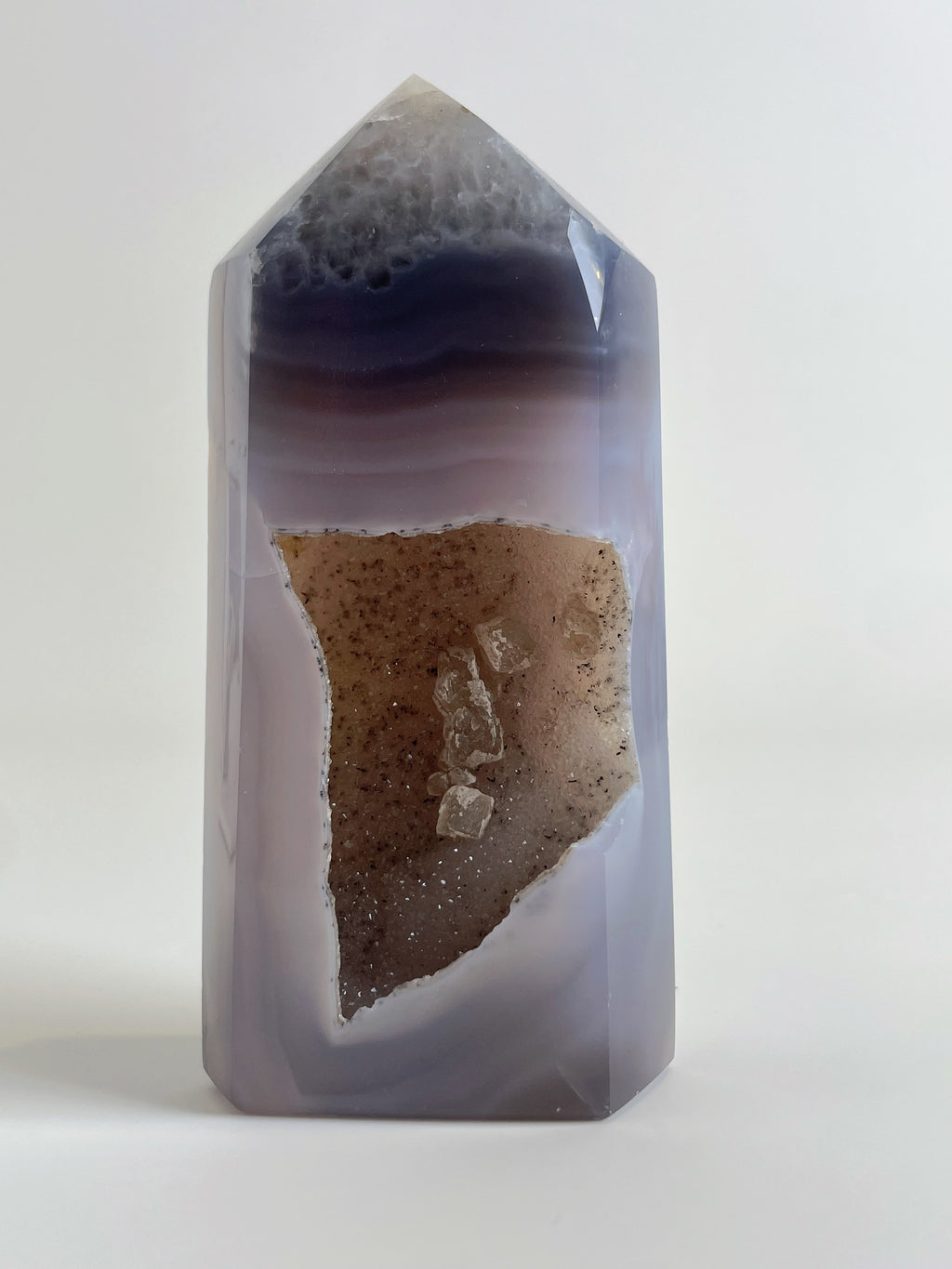 Druzy Agate Tower with smooth, layered purple and beige hues, featuring a sparkling crystal interior.