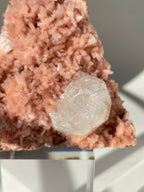 Beautiful pink Heulandite and Apophyllite crystal specimen with intricate textures, displayed on a clear pedestal.