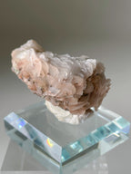 Beautiful pink petal calcite specimen on a clear display stand, showcasing delicate textures and soft hues.