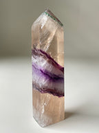 Rare banded fluorite tower showcasing beautiful purple and clear bands, reflecting light elegantly.