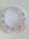 Beautiful Kunzite bracelet featuring 8mm pink stones and decorative silver accents, displayed on a clear stand.