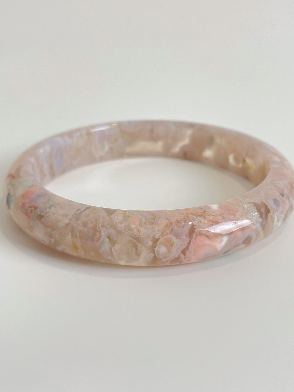 Beautiful flower agate bangle in soft pink hues, showcasing natural patterns and a smooth finish.