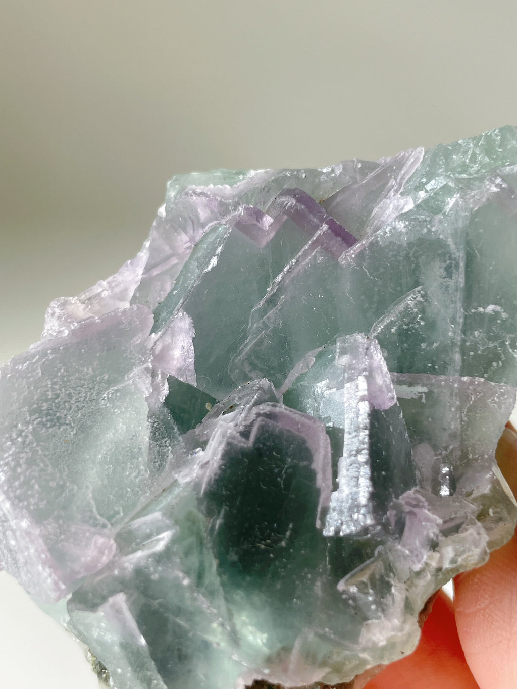 Beautiful fluorite crystal specimen showcasing vibrant green and purple hues with a textured surface.