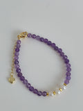 Faceted amethyst and pearl bracelet featuring 4mm beads with a gold clasp and heart charm.