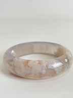 Beautiful flower agate bangle showcasing soft pink and cream hues, highlighting its unique crystal patterns.