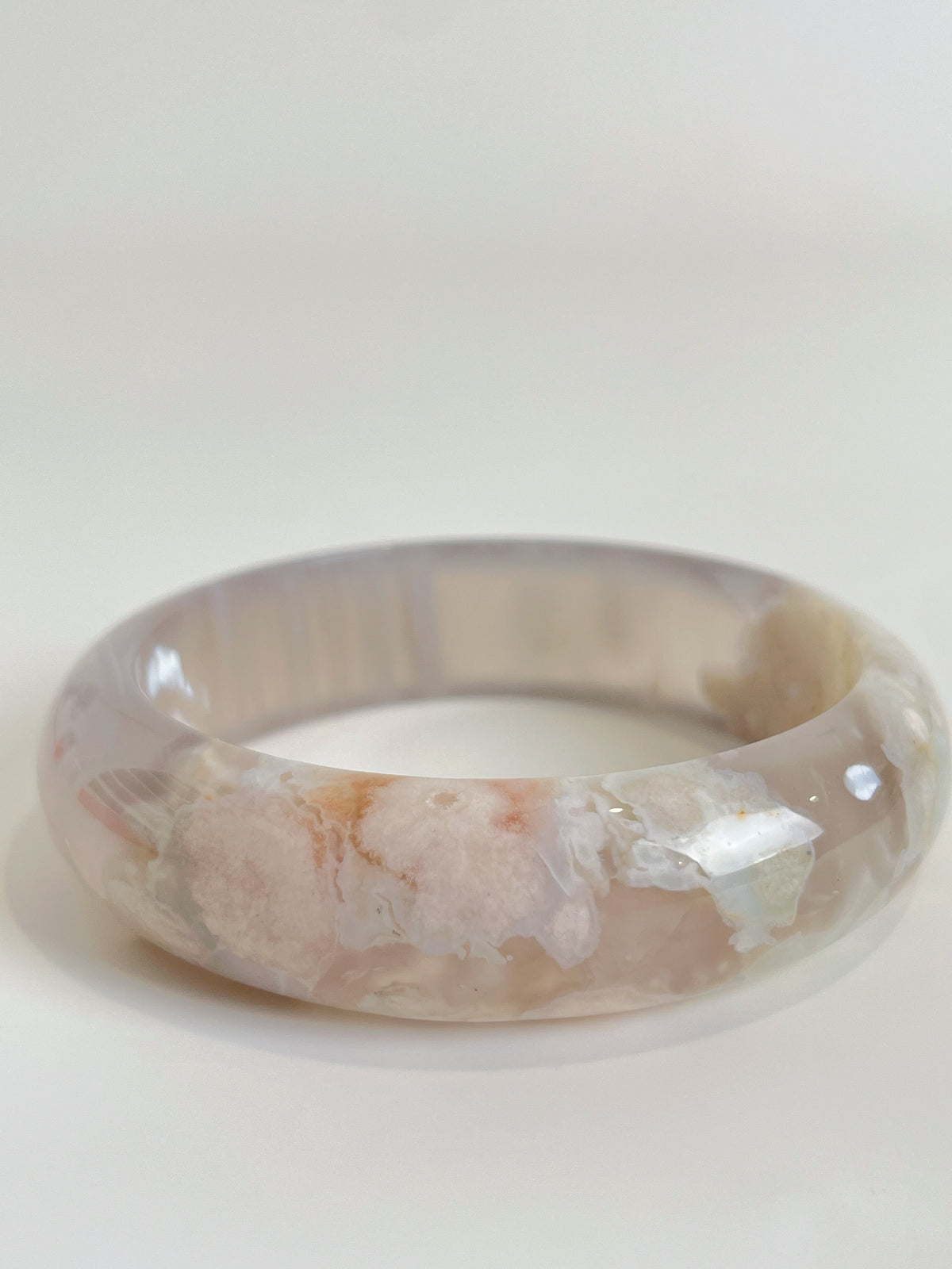 Beautiful flower agate bangle showcasing soft pink and cream hues, highlighting its unique crystal patterns.