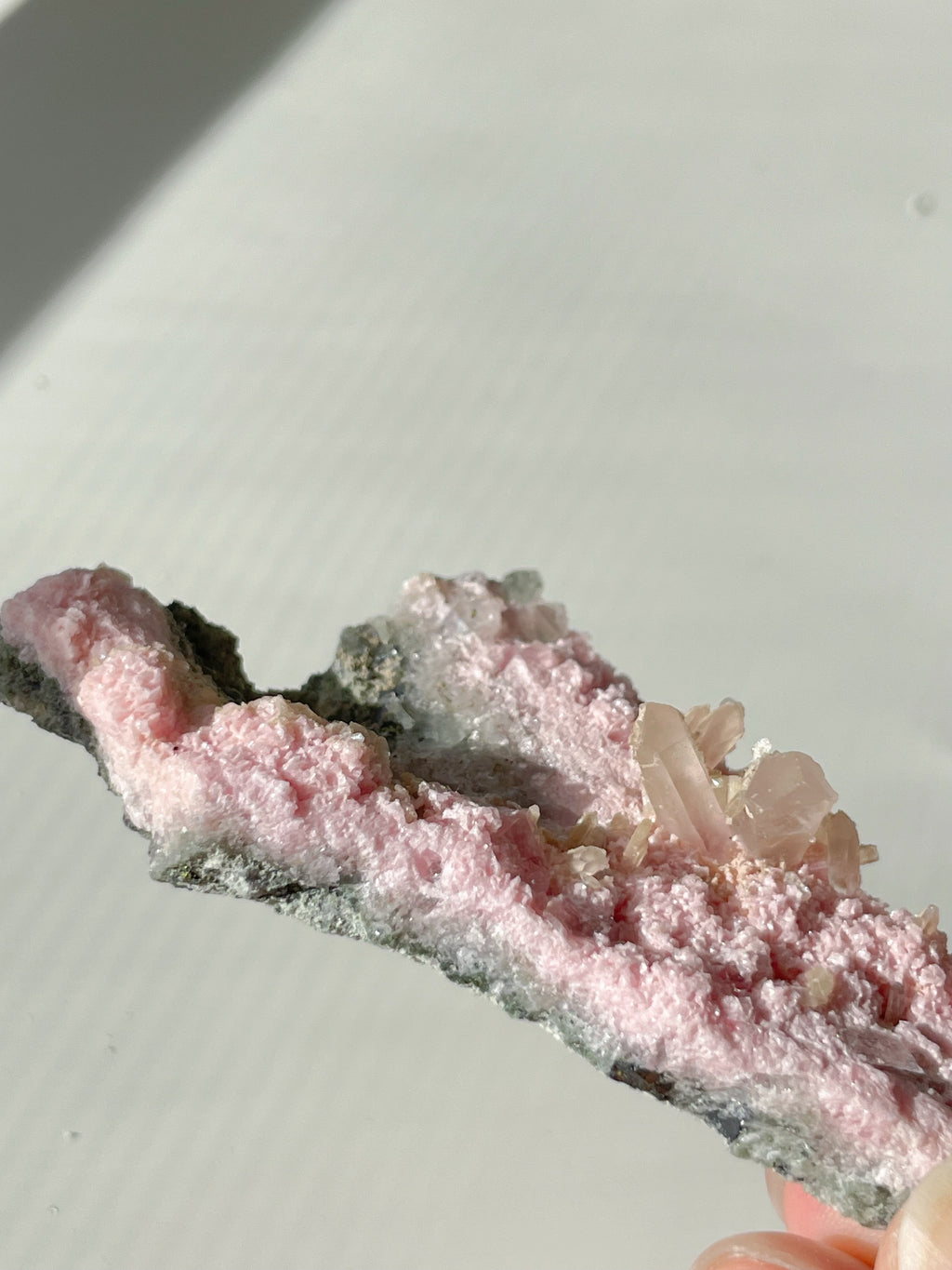 Rhodochrosite cluster with soft pink hues and crystal formations, showcasing natural beauty and texture.