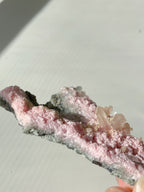 Rhodochrosite cluster with soft pink hues and crystal formations, showcasing natural beauty and texture.