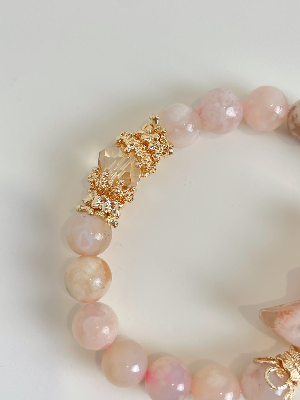 Beautiful flower agate bracelet featuring 9mm beads and a decorative gold clasp, showcasing soft pink hues.
