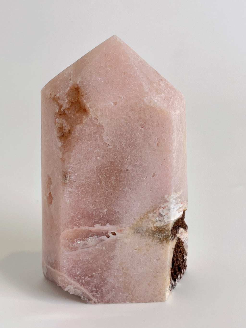 Beautiful pink amethyst tower with a smooth surface and a pointed top, showcasing natural variations and inclusions.