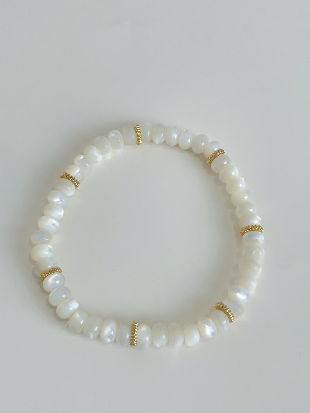 Elegant mother of pearl bracelet featuring smooth white beads and gold accents, perfect for any occasion.
