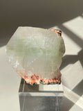 Beautiful crystal specimen featuring pink Heulandite and Apophyllite on a clear display stand, showcasing natural textures.