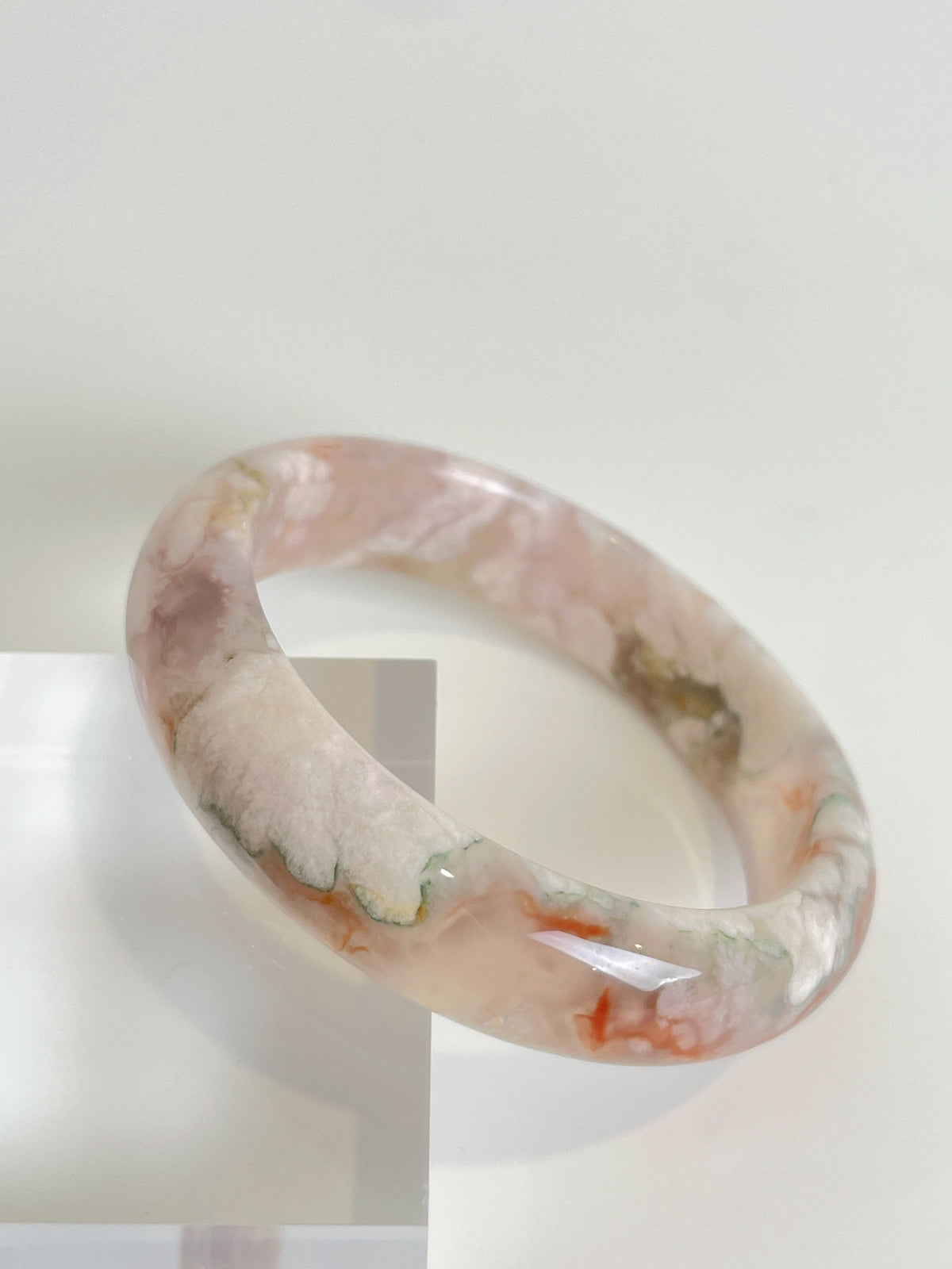 Beautiful flower agate bangle showcasing soft pink and green hues, elegantly displayed on a light background.