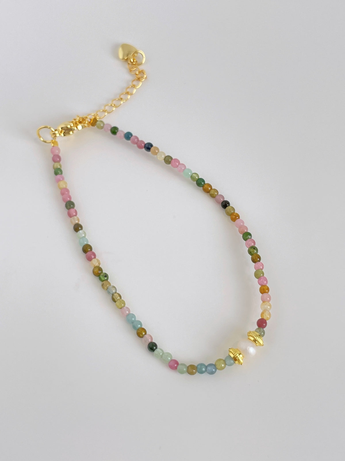 Colorful tourmaline and pearl bracelet featuring a mix of pastel beads and gold accents, perfect for layering.