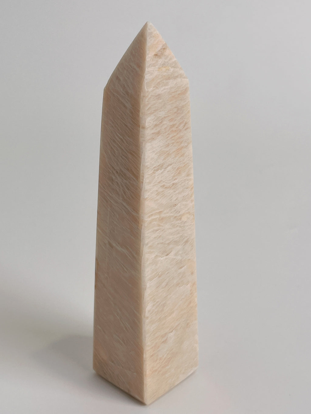Peach Scolecite tower with a smooth, pointed shape, showcasing soft peach tones and a polished finish.