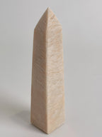 Peach Scolecite tower with a smooth, pointed shape, showcasing soft peach tones and a polished finish.