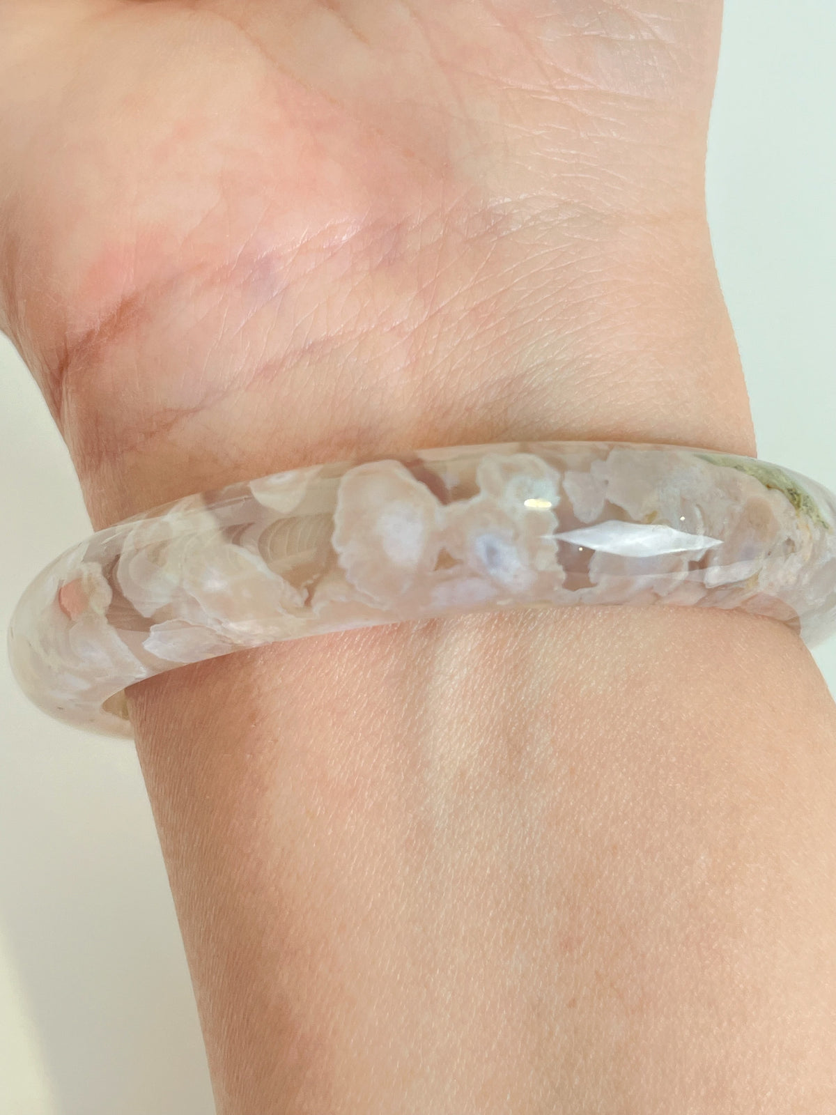 Beautiful flower agate bangle showcasing delicate floral patterns, worn on a wrist.