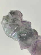 Beautiful crystal specimen featuring translucent green and purple hues, showcasing unique natural formations.