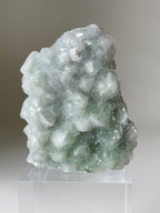 Beautiful green fluorite crystal specimen with a textured surface, displayed on a clear stand.