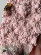 Beautiful rhodochrosite cluster showcasing delicate pink crystal formations with a textured surface.