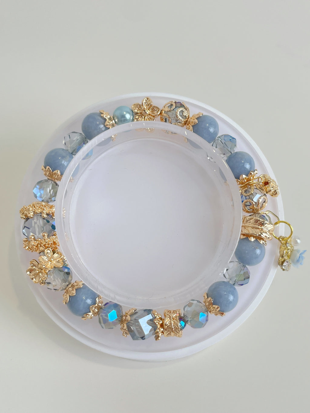 Beautiful angelite bracelet featuring 8.5mm beads, adorned with sparkling gold accents and crystal details.