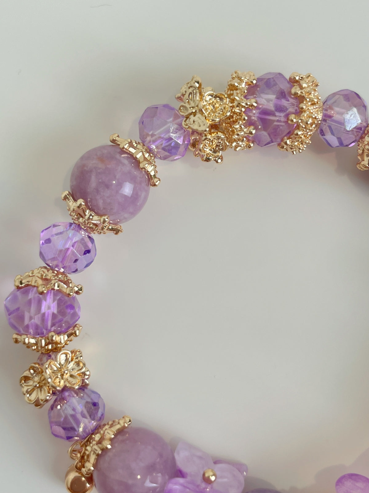 Lepidolite butterfly bracelet featuring 10.5mm purple beads and golden floral accents, showcasing a beautiful crystal design.