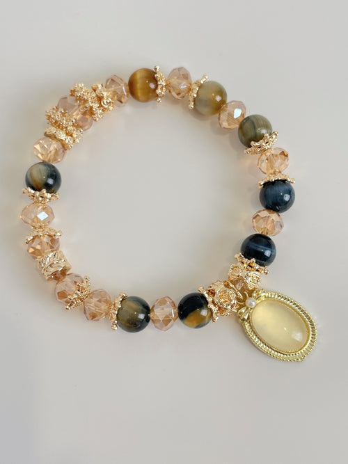 Blue Tiger's Eye bracelet featuring 8.5mm beads, accented with sparkling crystal and gold-tone details.