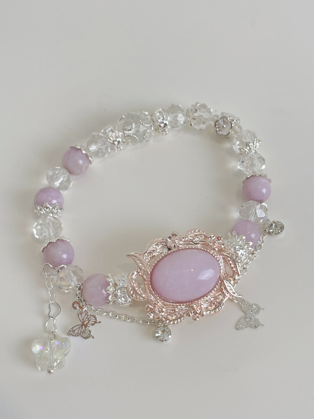 Beautiful bracelet featuring pink amethyst and sparkling crystal accents, adorned with delicate butterfly charms.