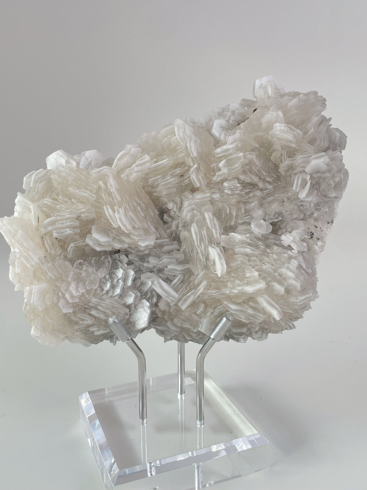 Biscuit Calcite specimen showcasing intricate crystal formations, displayed elegantly on a clear stand.