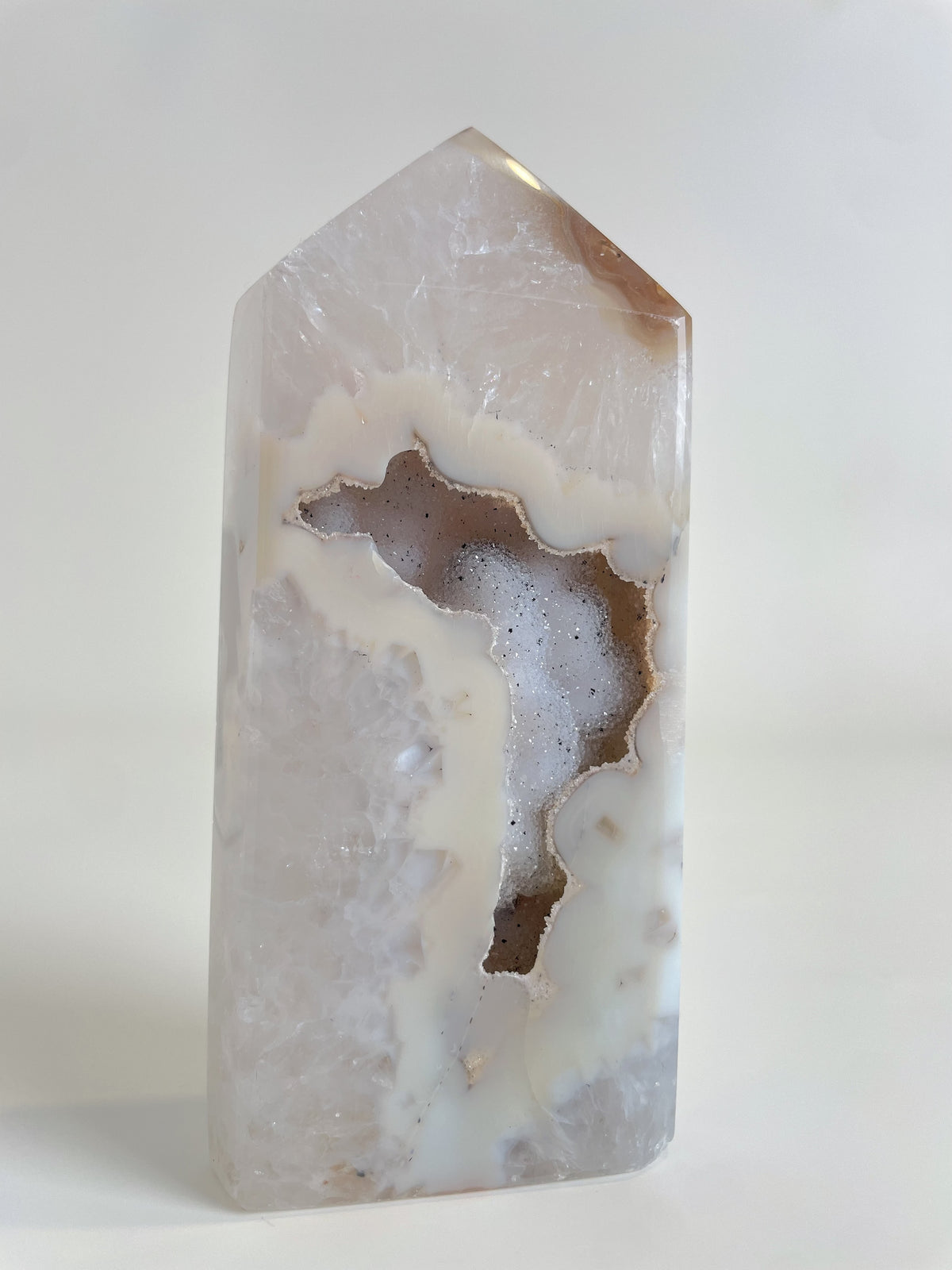 Druzy agate tower with a smooth, polished surface showcasing natural patterns and a light color palette.