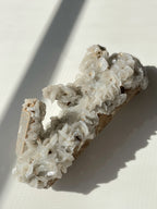 Beautiful crystal specimen featuring intricate flower calcite formations on a quartz base, showcasing natural textures.