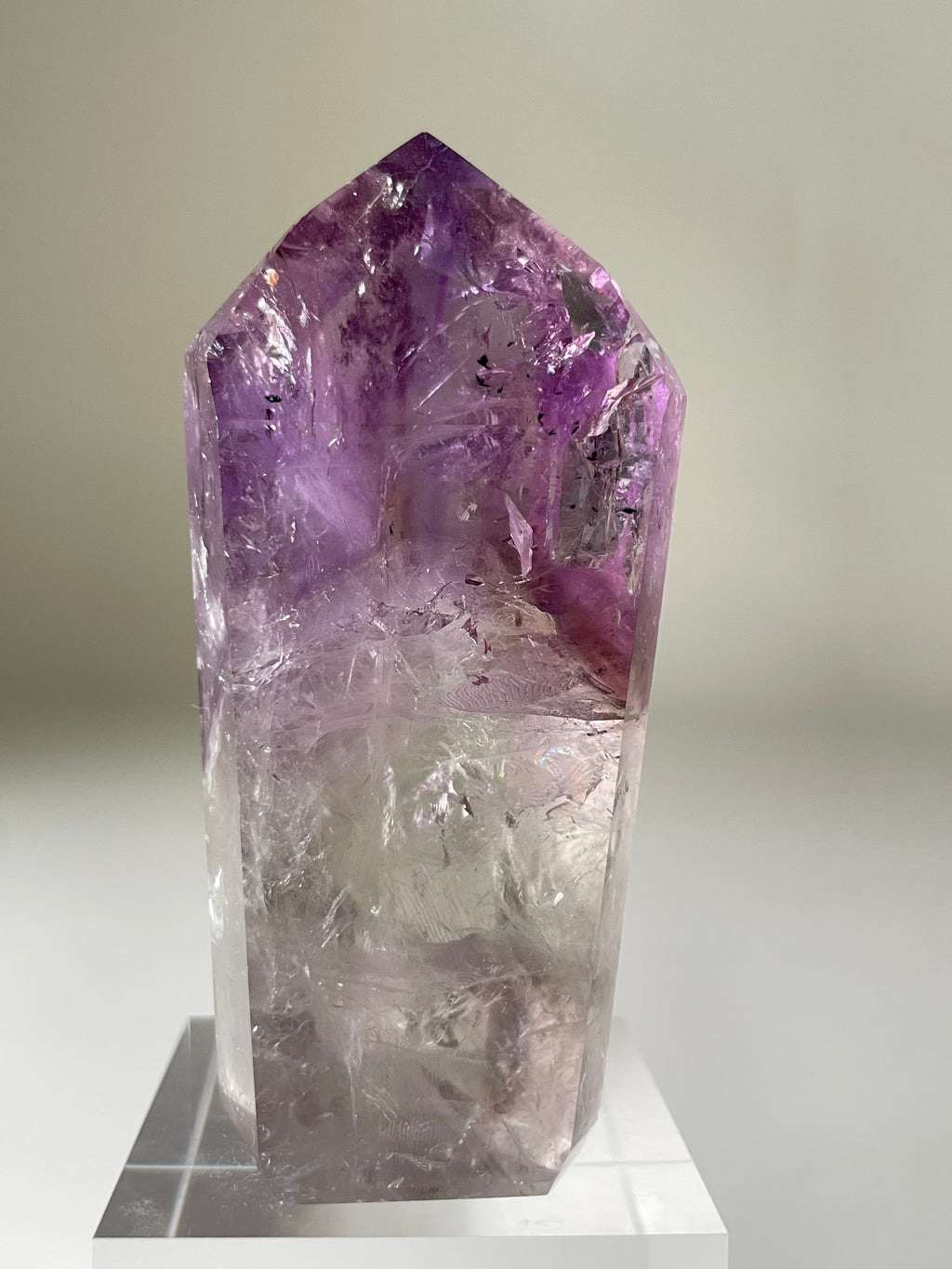 A stunning Brazilian Phantom Amethyst tower with vibrant purple hues, showcasing intricate crystal formations.