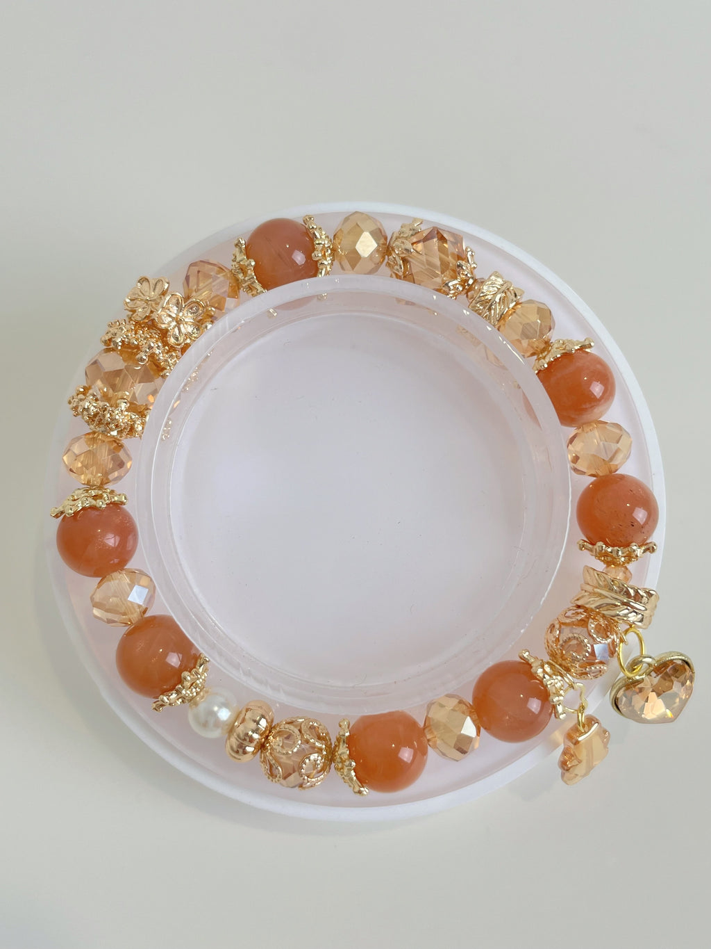 A beautiful sunstone bracelet featuring warm orange beads and sparkling golden accents, elegantly displayed.