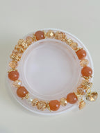 A beautiful sunstone bracelet featuring warm orange beads and sparkling golden accents, elegantly displayed.