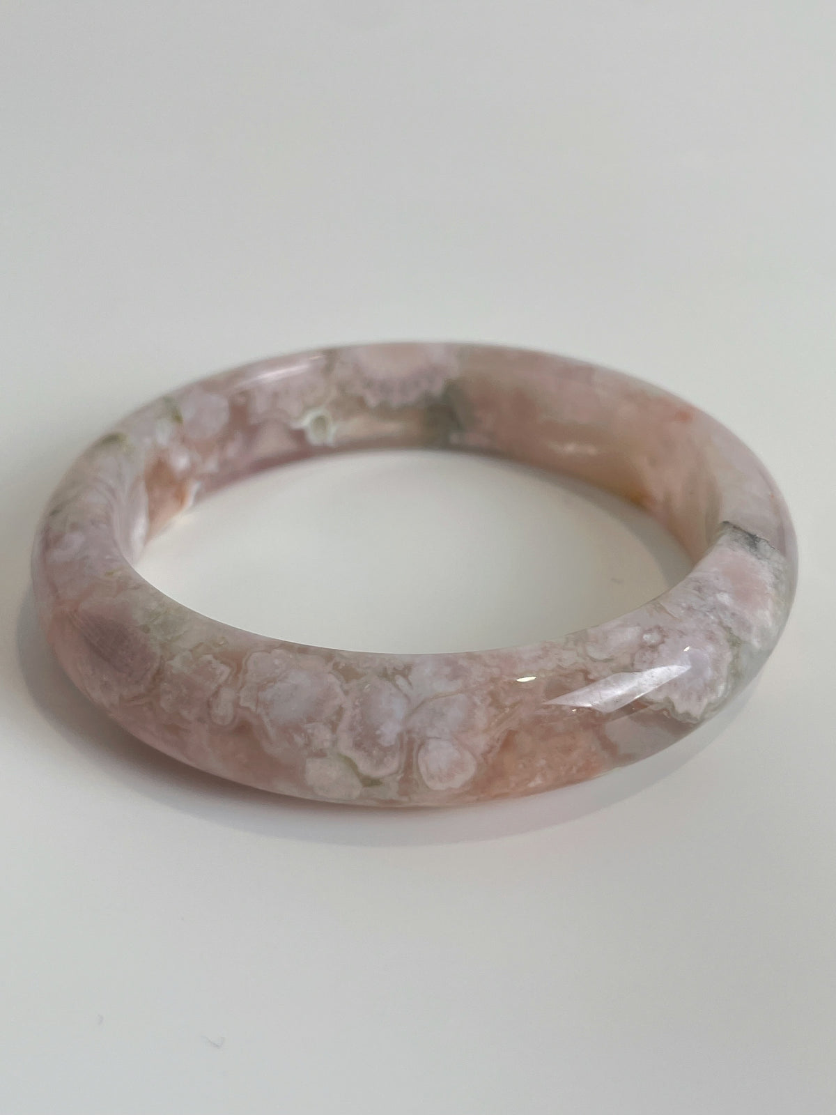 Beautiful flower agate bangle with soft pink hues and unique patterns, showcasing its natural crystal beauty.