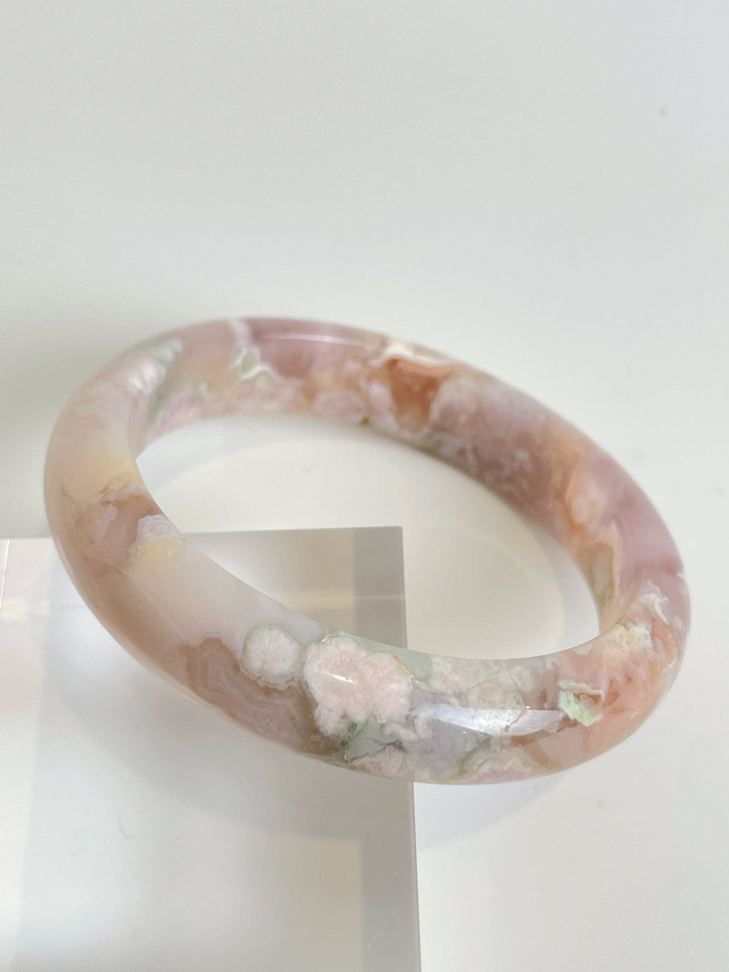 Beautiful flower agate bangle featuring soft pink and cream hues, showcasing natural patterns and textures.
