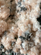 Close-up of pink calcite with quartz and arsenopyrite, showcasing intricate crystal formations and textures.