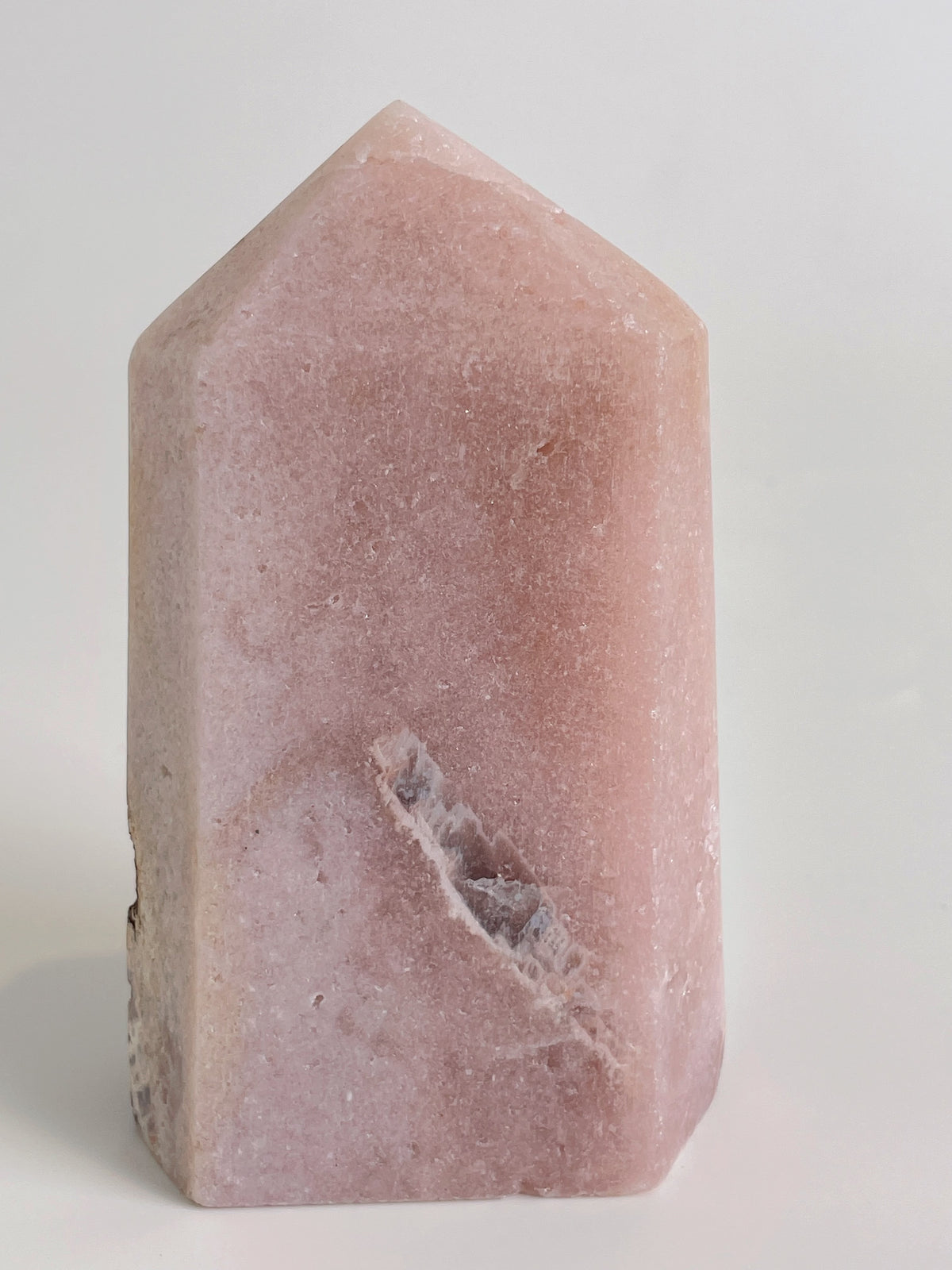 Beautiful pink amethyst tower with a smooth surface and a pointed top, showcasing natural mineral patterns.