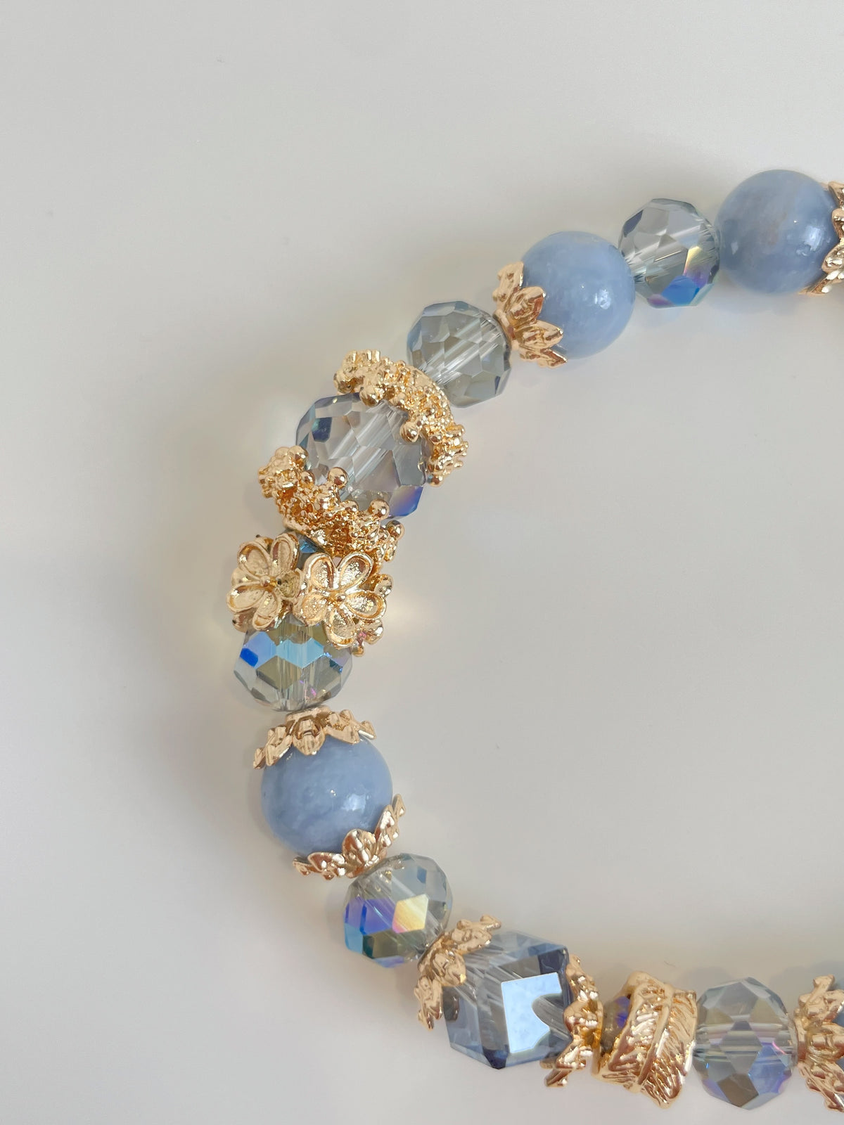 Beautiful angelite bracelet featuring 8.5mm beads, adorned with sparkling accents and floral details.