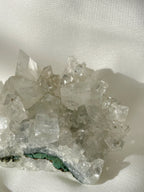 A stunning apophyllite cluster with clear, sparkling crystals resting on a soft surface.