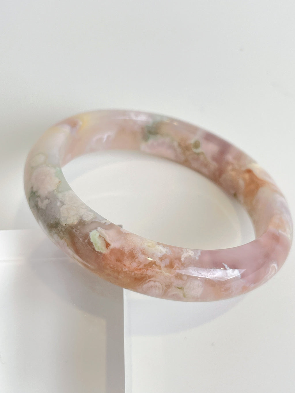 Beautiful flower agate bangle featuring soft pink and earthy tones, showcasing unique patterns and textures.